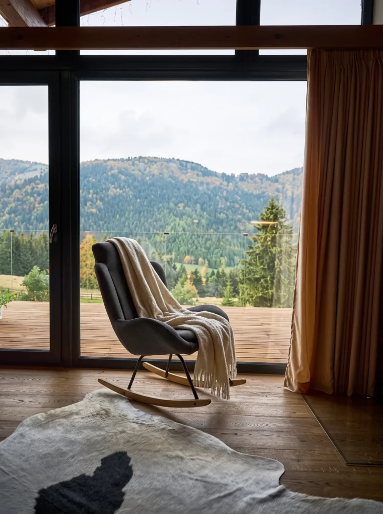 Apartmán na Donovaloch, hojdacie kreslo pri okne s výhľadom na hory