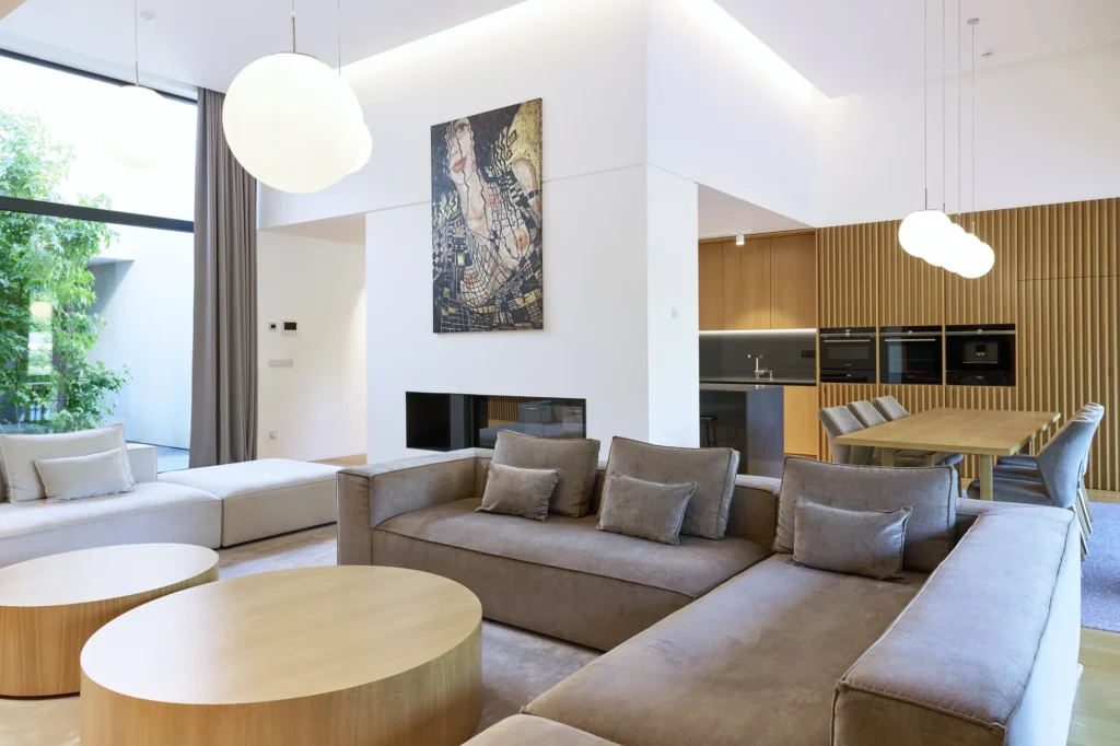 Villa 91, obývacia izba so sedačkou, krbom a jedálňou s kuchyňou